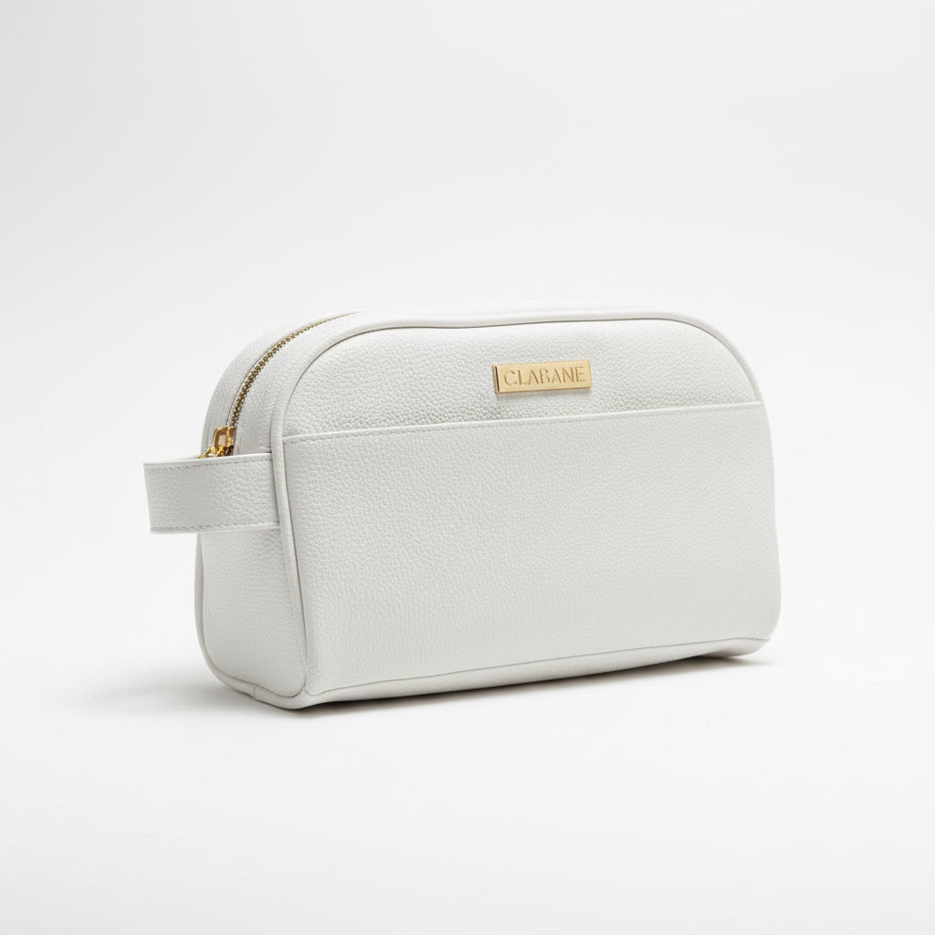 White toiletry bag with a the CLABANE brand logo on a gray surface